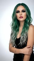 Young woman with vibrant green ombre hair and dramatic makeup wearing black sequined dress on white background for fashion and beauty concepts.