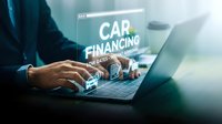 Professional businessman using laptop for car financing application with digital interface displaying loan rates and automotive purchase options.