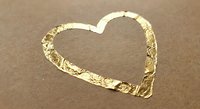 Heart shape drawn in wet sand on beach with golden sunlight reflection creating romantic seaside love symbol for Valentine's Day and wedding concepts.