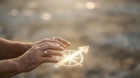 Mature hand holding glowing arrow symbol pointing upward, representing growth, success, and positive direction for business and motivational concepts.