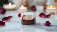 Luxurious burgundy glass cosmetic jar with metallic gold lid surrounded by rose petals and glowing candles on white marble surface, spa and beauty product photography.