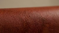 Close-up of rich burgundy leather texture with natural grain and subtle surface variations, suitable for design backgrounds and material references.