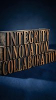Wooden letterpress blocks spelling integrity innovation collaboration on blue background for business concepts and corporate communications.