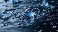 Macro photography of water drops creating spherical formations on dark surface with dramatic lighting and reflections, showing surface tension and liquid dynamics.