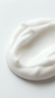 Creamy white cosmetic product with smooth, luxurious texture swirled on neutral background, suitable for skincare, beauty, and wellness marketing materials.