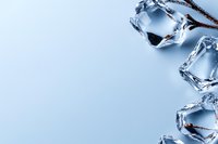 Clear ice cubes with sharp edges and crystalline structure arranged on light blue background with copy space, creating minimalist composition for beverage and cooling concepts.
