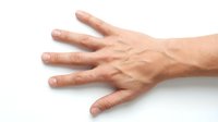 Mature adult male hand with visible veins and age spots displayed on white background, suitable for healthcare, aging, dermatology, and medical educational materials.