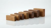 Wooden blocks arranged in ascending staircase pattern on white background, representing growth, progress, and business development concepts for corporate and educational design projects.