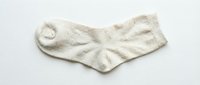 Cozy cream knitted cotton ankle sock lying flat on a white background, isolated for clothing, fashion, and retail design use.