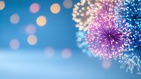 Festive fireworks display against blue night sky with soft bokeh lights creating magical holiday atmosphere. Celebration background for greeting cards.