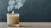 Burning candle with dramatic white smoke swirls against dark background creating atmospheric mood for relaxation and aromatherapy concepts.