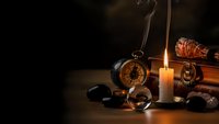 Vintage compass, candle, rope and nautical items on wooden table creating atmospheric maritime adventure scene with warm candlelight and dark background.