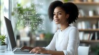 Young African American woman with natural hair working on laptop with digital marketing icons floating beside her, smiling while typing in modern home office.
