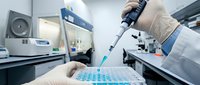 Laboratory scientist using electronic pipette for precise sample dispensing in modern research facility with advanced equipment and sterile environment.