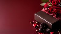 Elegant chocolate gift box with red roses and berries on burgundy background for Valentine's Day, anniversary, romantic occasions and luxury present concepts.