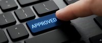Finger pressing blue approved button on dark keyboard, symbolizing confirmation, acceptance, and authorization in business and digital processes.
