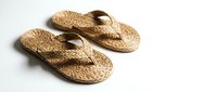 Pair of woven straw flip-flops with natural fiber construction and dark brown accents, suitable for summer footwear, casual wear, and resort styling.