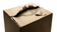 Torn cardboard box with ripped edges and exposed corrugated interior, showing damage and wear. Suitable for packaging, shipping, recycling, and waste management concepts.