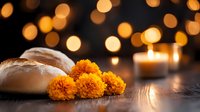Marigold flowers and bread on wooden surface with glowing candles and bokeh lights creating spiritual atmosphere for traditional ceremony or offering.