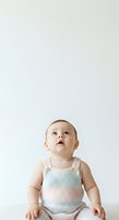 Caucasian baby girl, approximately 12-18 months old, wearing pastel striped knit tank top, looking upward with curious expression against white background, isolated for design use.