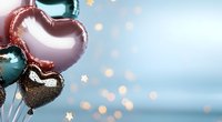 Heart-shaped balloons in rose gold and black with sparkling bokeh lights background for romantic celebrations and love themed events.