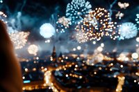 Blurred fireworks display over city lights creating bokeh effect for celebration backgrounds and festive designs.