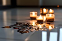Glowing tea light candles arranged on decorative metallic snowflake pattern creating warm atmospheric lighting and festive reflections on glossy surface.