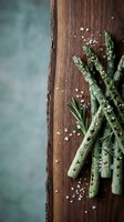 Fresh green asparagus spears with sea salt crystals on rustic wooden cutting board, healthy organic vegetable ingredient for cooking and culinary preparation.