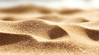 Macro view of golden desert sand dunes with soft shadows and light texture creating abstract natural waves and ripples in sunlight. For backgrounds and wallpapers.