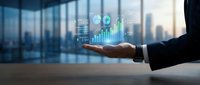 Businessman holding digital hologram with financial charts and graphs above palm, cityscape background, representing data analytics and business growth.