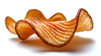 Crispy wavy potato chip with ridged surface and golden-brown color isolated on white background, showing texture and curves for food packaging design.