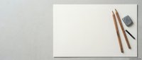 Blank white paper sheet with wooden pencils and eraser on neutral background for creative projects and artistic work.