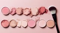 Crushed makeup powder samples in pink and coral shades with professional makeup brush on pink background, flat lay composition for beauty and cosmetics industry.