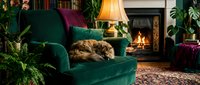 Cozy living room interior with tabby cat sleeping on emerald green armchair near warm fireplace, creating peaceful domestic atmosphere for home decor concepts.