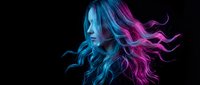 Young woman with vibrant blue and pink hair in motion against black background. Creative portrait with neon lighting effects for fashion design.