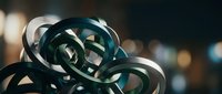 Abstract metallic ribbons intertwined in elegant curves creating dynamic sculptural form with reflective surfaces and bokeh background lighting effects.