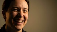 Happy middle-aged Caucasian woman with genuine smile and warm expression in soft natural lighting for lifestyle and wellness content.