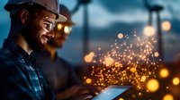 Industrial worker in hard hat using digital tablet with glowing sparks effect at construction site during evening hours for safety and productivity applications.