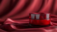 Red cosmetic cream jar on luxurious burgundy silk fabric with soft folds and dramatic lighting, showcasing premium skincare product packaging for beauty industry.