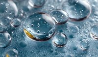 Crystal clear water droplets with golden accent on blue surface creating abstract liquid texture for wellness and purity concepts in commercial design.