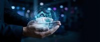 Businessman holding glowing digital factory hologram with industrial automation icons representing smart manufacturing and Industry 4.0 technology concepts.