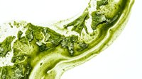 Okra vegetable sliced in half showing fresh green flesh and seeds on white background for food and cooking content.