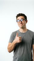 Young man with dark hair and fair complexion wearing clear-framed glasses and gray t-shirt giving thumbs up gesture against white background, isolated for advertising and promotional use.
