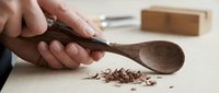 Wooden spoon holding crushed dried herbs and spices for cooking, food preparation, seasoning ingredients, culinary arts, and kitchen use.