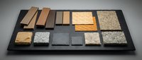 Construction material samples display board showcasing wood planks, stone tiles, concrete slabs and textured surfaces for architectural design projects.