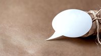 White speech bubble note tied with twine on kraft paper background, minimalist communication concept with copy space for message or quote.