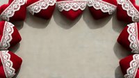 Red velvet ribbon with white lace trim arranged in decorative border frame on neutral linen fabric background for crafting and holiday decoration projects.