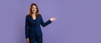 Professional businesswoman in navy suit presenting with open palm gesture on purple background for corporate marketing and business presentations.