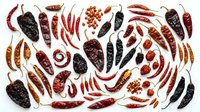 Assorted dried chili peppers and red pepper seeds arranged on white background, isolated for culinary, cooking, spice, and food design projects.