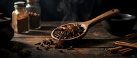 Aromatic star anise spices in wooden spoon on rustic kitchen table with cinnamon sticks and glass jars for culinary cooking and baking recipes.